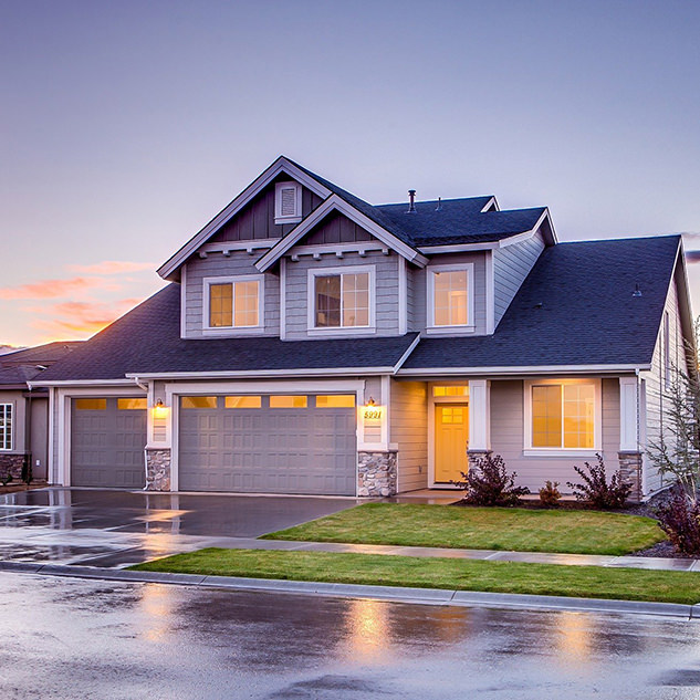 Front of two story house at dusk with indoor and outdoor lights turned on