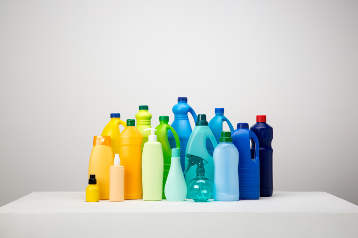 Group of different sized plastic bottles in varying colors from yellow, green and blue without labels